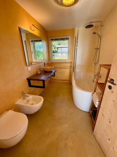 a bathroom with a toilet and a tub and a sink at Panoramic views on Monte Generoso, peace & nature in Castel San Pietro