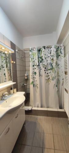 a bathroom with a sink and a shower curtain at GDE SPETSES 3bdr HOUSE in Spetses