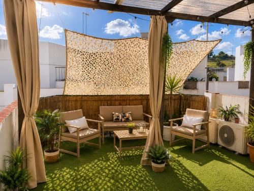 a patio with chairs and a table on a roof at Dúplex con Piscina y Terraza a 5 min de Sevilla in Camas