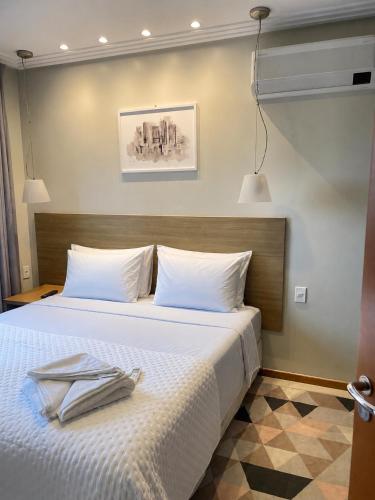 a bedroom with a white bed with towels on it at Apollos Garden in Belém