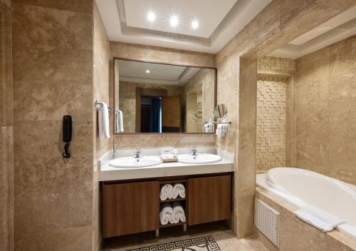 a bathroom with two sinks and a tub and a mirror at Hotel Bellwood Near IGI International Delhi Airport in New Delhi