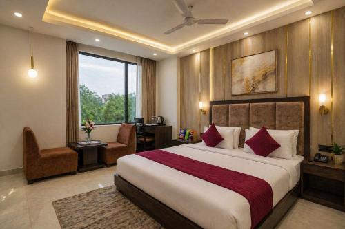 a hotel room with a large bed and a chair at Hotel Bellwood Near IGI International Delhi Airport in New Delhi