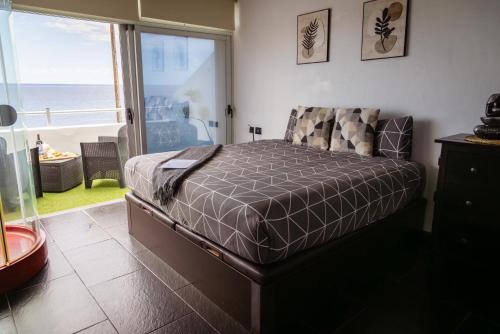 a bedroom with a bed with a view of the ocean at Live Puertito Neptune Beach in Puertito de Güímar