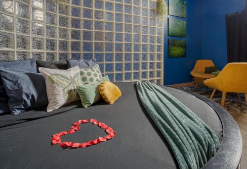 a bedroom with a bed with a red necklace on it at chambre AZZURO avec jacuzzi lit rond et jardin avec piscine in Saint-Martial-sur-Né