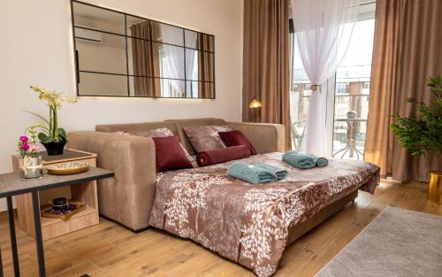 a living room with a couch and a bed at Apartman Srebrni Horizont in Veliko Gradište