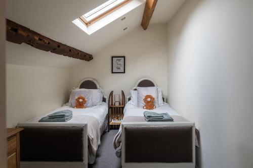 a bedroom with two beds with teddy bears on them at The Damson Barn in Biddulph