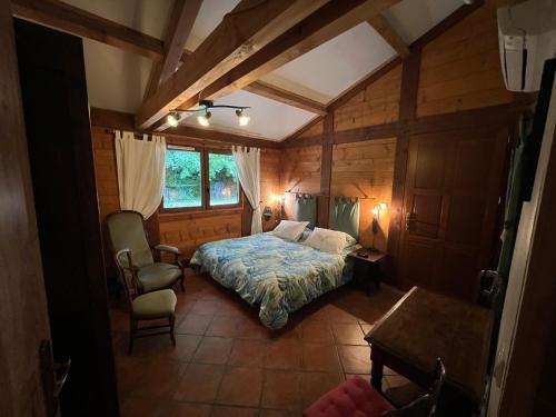 a bedroom with a bed and a chair in a room at Chambre D'hôtes Du Mas in Saint-Vitte-sur-Briance