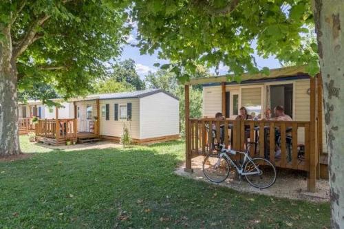 a group of people sitting on a porch of a caravan at Camping 3 étoiles - Piscine - ccbgaae in Mens