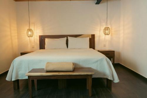 a bedroom with a bed with a table and two lights at Tapalpa Hotel Casa Colibrí in Tapalpa