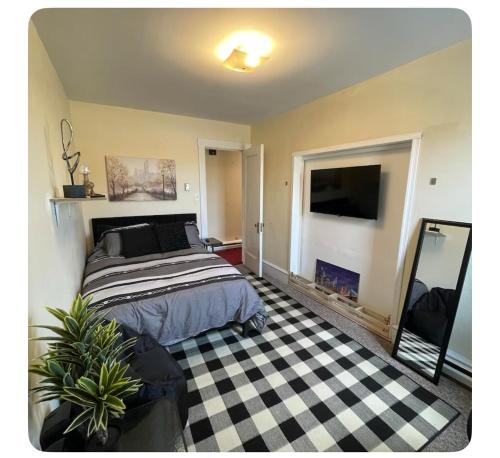 a bedroom with a bed and a black and white checkered floor at Serendipity Corner Guesthouse in Wilkes-Barre