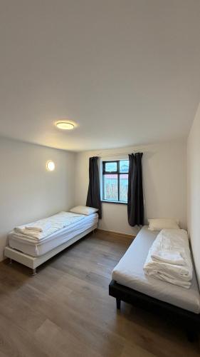 two beds in a room with a window at Ocean View Guesthouse in Borgarnes