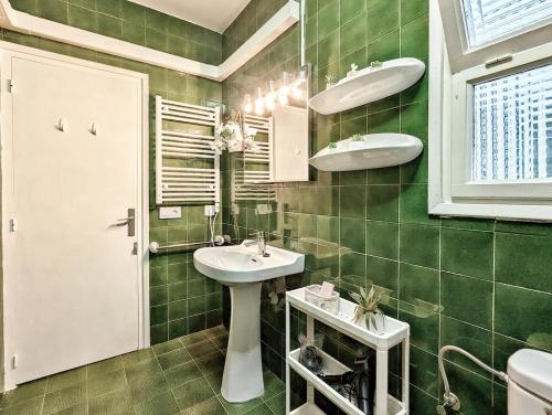 a green tiled bathroom with a sink and a mirror at Estartit Centro in L'Estartit