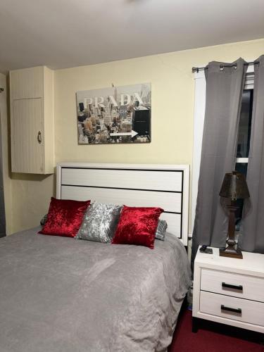 a bedroom with a bed with red pillows on it at Serendipity Corner Guesthouse in Wilkes-Barre