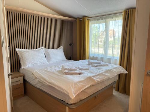 a bedroom with a bed with towels on it at Green Lodge Bran in Bran