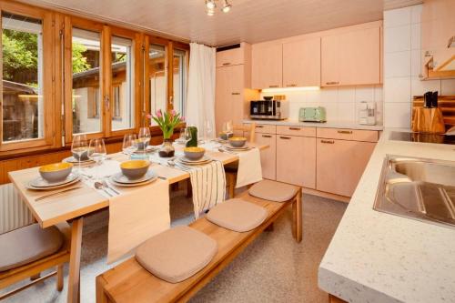 a kitchen with a table and chairs and a sink at Staubbach View - Traditional Chalet Apartment in Lauterbrunnen
