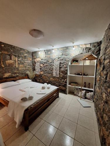 a bedroom with a large bed and a stone wall at Sidirounta Village Apartment in Sidiroúnta