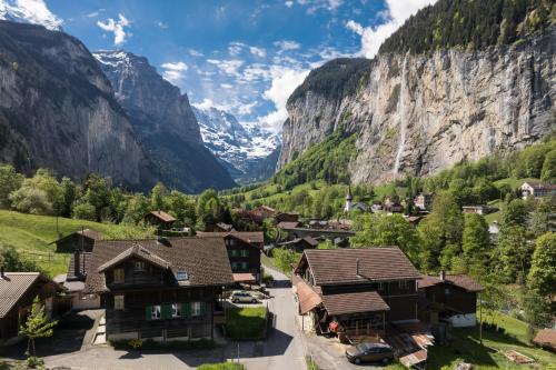 a village in a valley with mountains in the background at Staubbach View - Traditional Chalet Apartment in Lauterbrunnen