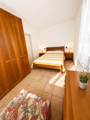 a bedroom with a bed and wooden cabinets and a table at PETRONIA TRILO VISTA MARE - Agenzia Cocal in Caorle