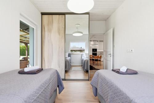 two beds in a room with a kitchen and a living room at Rukkilille majutus in Herjava