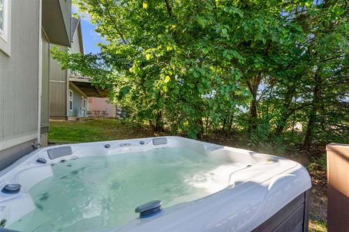 a hot tub in a yard with a tree at Hickory Hideaway with Communal Pool Access in Hollister