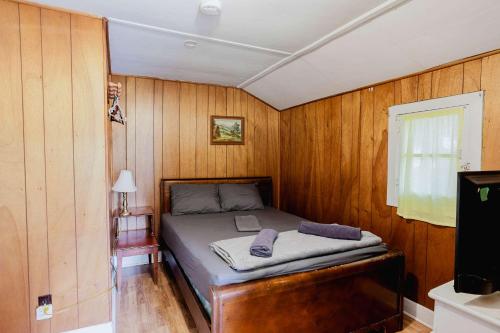 a bedroom with a bed in a wooden wall at 1-Bedroom Cottage #2 - Ambleside in Kawartha Lakes