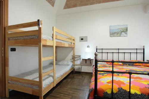 sypialnia z 2 łóżkami piętrowymi i biurkiem w obiekcie Aurora Bed and Breakfast w mieście Santo Stefano di Camastra