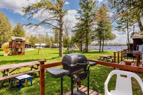 a barbecue grill in a park with a playground at 1-Bedroom Cottage #2 - Ambleside in Kawartha Lakes