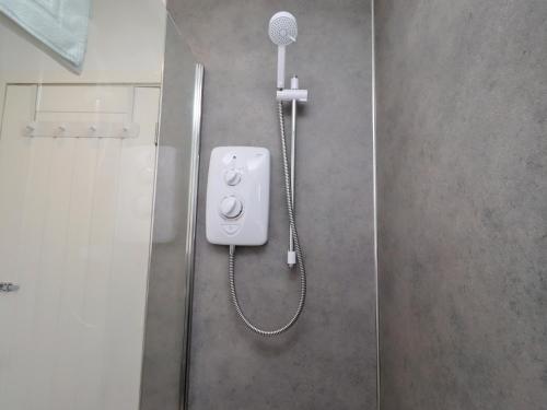a shower in a bathroom with a shower head at 22 Longstone Park in Chathill