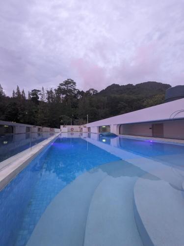 a large swimming pool with blue water in front of a building at 2BR Fantasea condo kamala in Kamala Beach