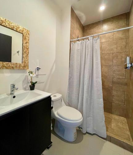a white bathroom with a toilet and a sink at La Jolla in Bejuco