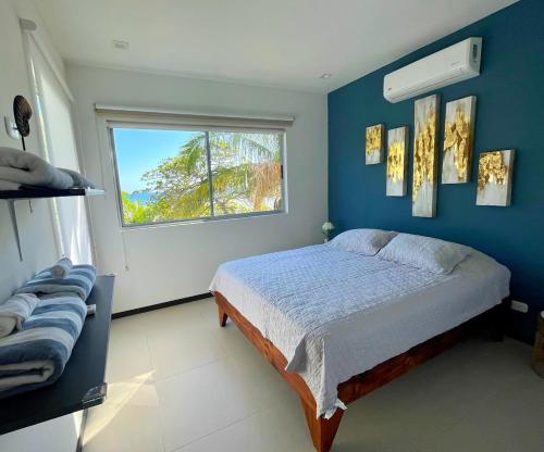 a bedroom with a bed with a blue wall at La Jolla in Bejuco