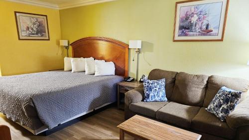 a hotel room with a bed and a couch at Magnuson Hotel Blythe in Blythe