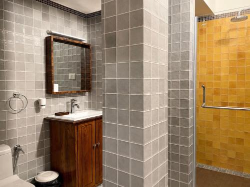 a bathroom with a sink and a shower with a mirror at Skylark Resort in Colva
