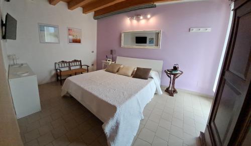 a bedroom with a white bed and purple walls at Villa Posta Vecchia in Loreo