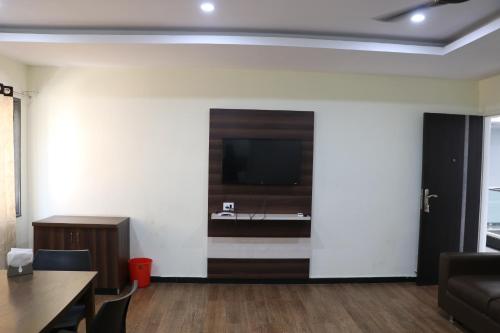 a living room with a flat screen tv on a wall at Hotel Satkar in Amalāpuram
