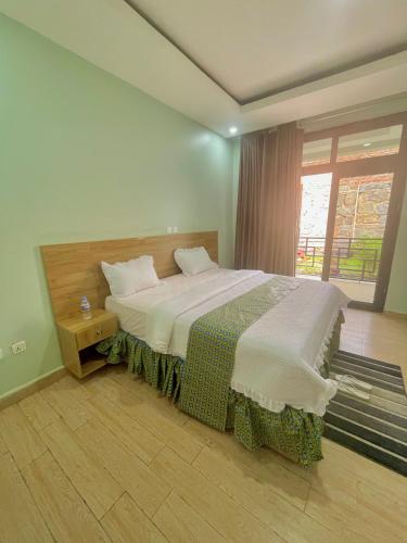 ein Schlafzimmer mit einem großen Bett und einem Fenster in der Unterkunft Ibigabiro Hotel in Kagano