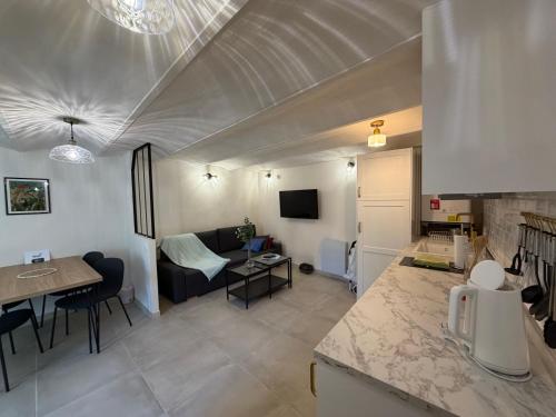 a kitchen and living room with a couch and a table at La maison jaune in Roquebrune-Cap-Martin
