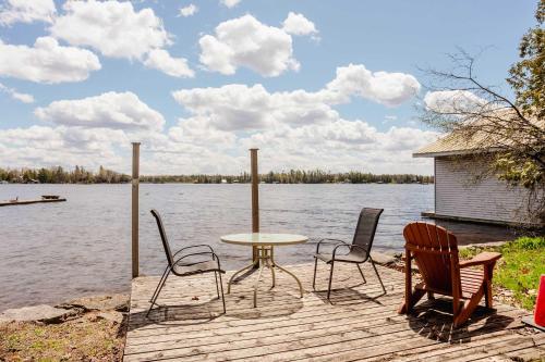 a table and chairs sitting on a dock next to the water at Ambleside - 2-Bedroom Cottage #4 in Kawartha Lakes