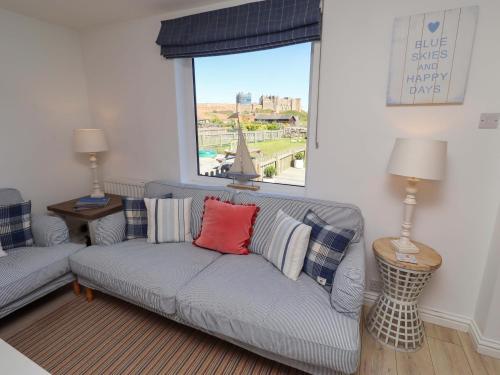 a living room with a couch and a window at Dunford Cottage in Bamburgh