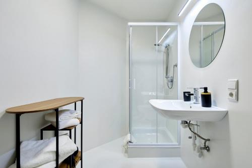 a white bathroom with a sink and a shower at Ladurnhof in Silandro