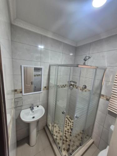a bathroom with a glass shower and a sink at Ithonsi Guesthouse in Kempton Park