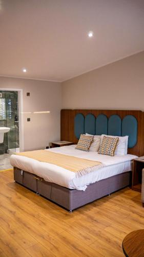 a large bed with a blue headboard in a room at Park Hall Cottages ,Chorley, Preston,Lancashire in Chorley
