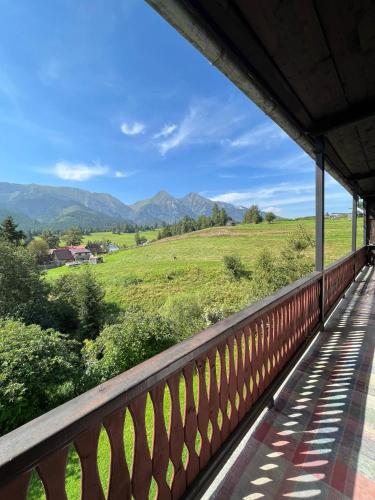 a balcony with a view of a field and mountains at U Milušky in Ždiar