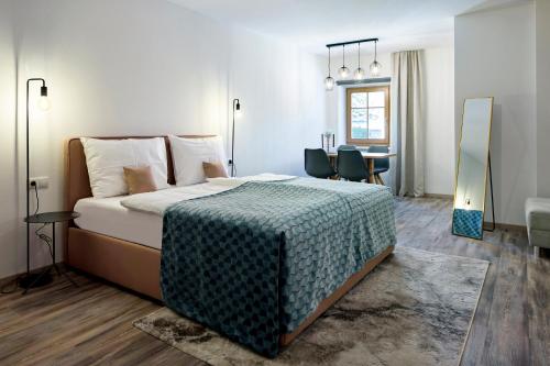 a bedroom with a large bed and a table at Ladurnhof in Silandro
