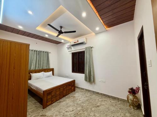 a bedroom with a bed and a ceiling fan at Tri Riverfront Homestay in Udupi