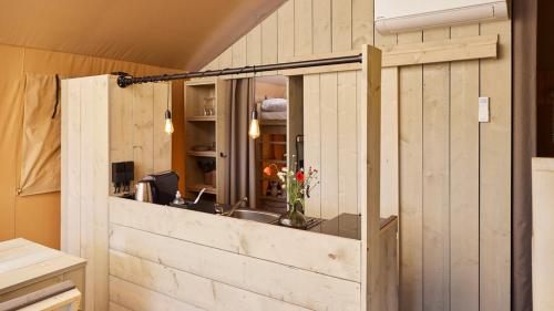a kitchen with a sink and a mirror at Fårup Skovbrynet in Saltum