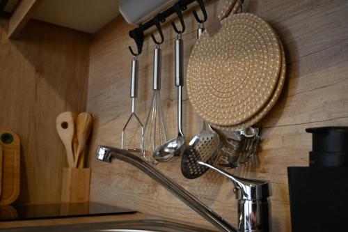 a kitchen counter with utensils hanging on a wall at Rilux Mobile Home "Camping Pirovac" in Pirovac