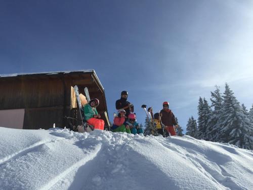 a group of people sitting on top of a snow covered slope at Sunnaschi Appartements - Wohnungen oder gesamt als "Hütte" in Laterns