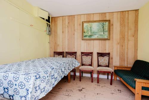 a bedroom with a bed and chairs and a picture at 3-Bedroom Cottage #7 - Ambleside in Kawartha Lakes