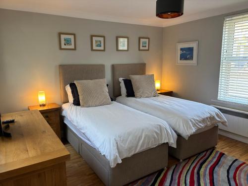 a bedroom with two beds and two lamps on tables at Aigua Blava in Carbis Bay